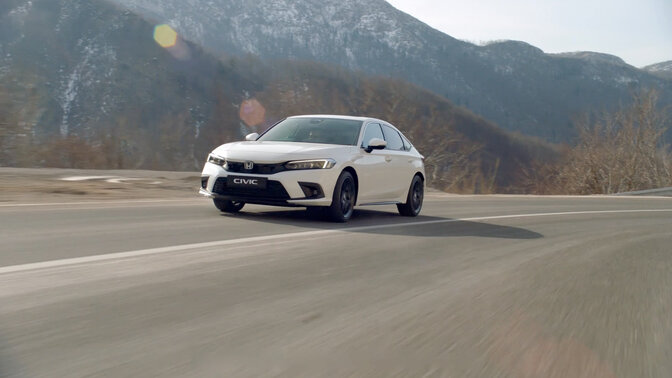Front facing Honda Civic Hybrid driving down the road. 